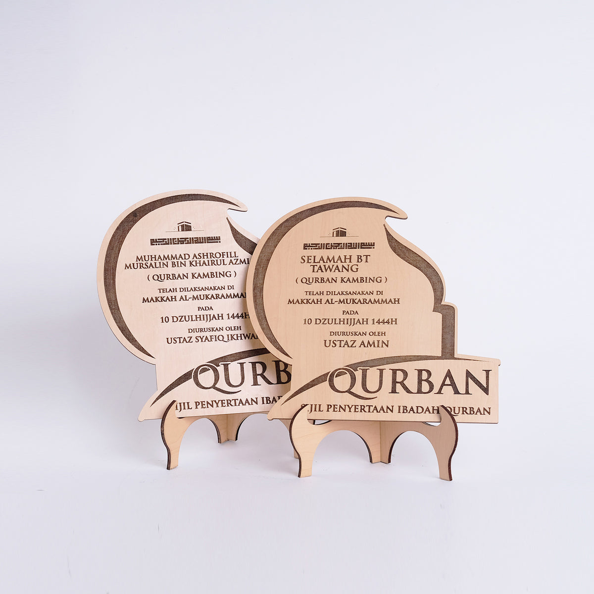 Wooden Qurban plaque with engraved text on a white background