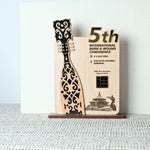 Wooden award with decorative design on a stand against a light background