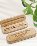 Wooden pen set with engraved message on a light background