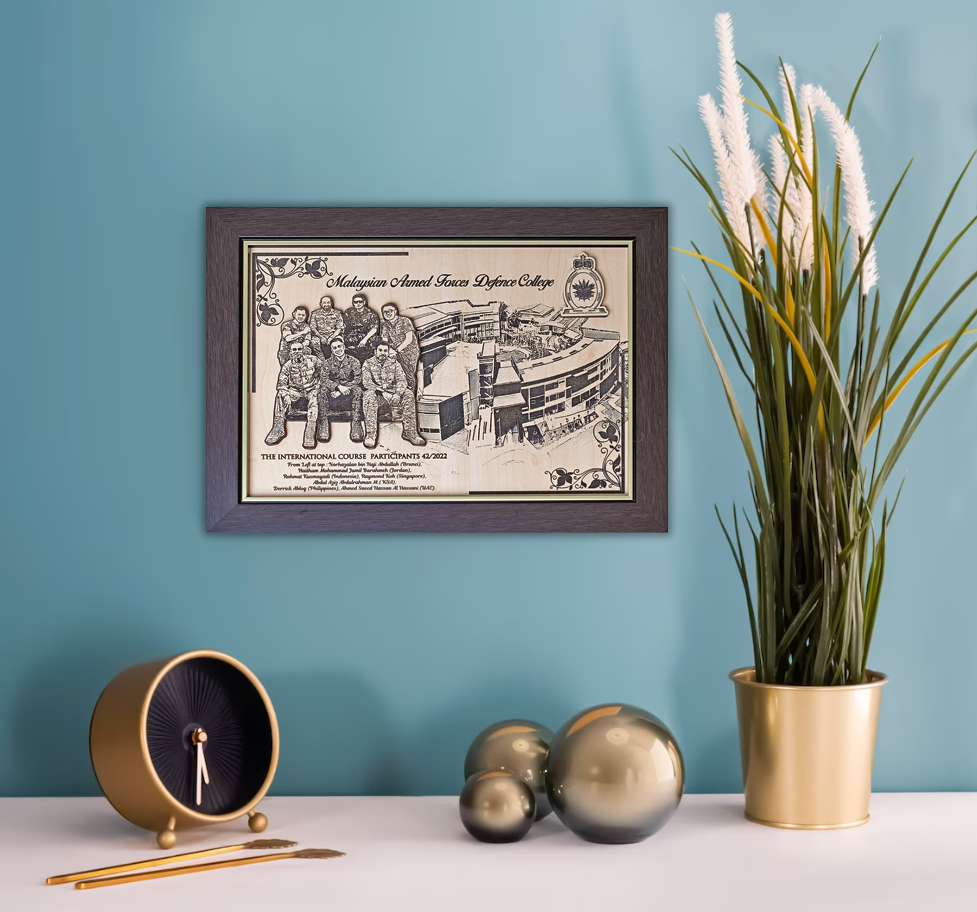 Framed black and white print of a group photo on a blue wall with decorative items below.
