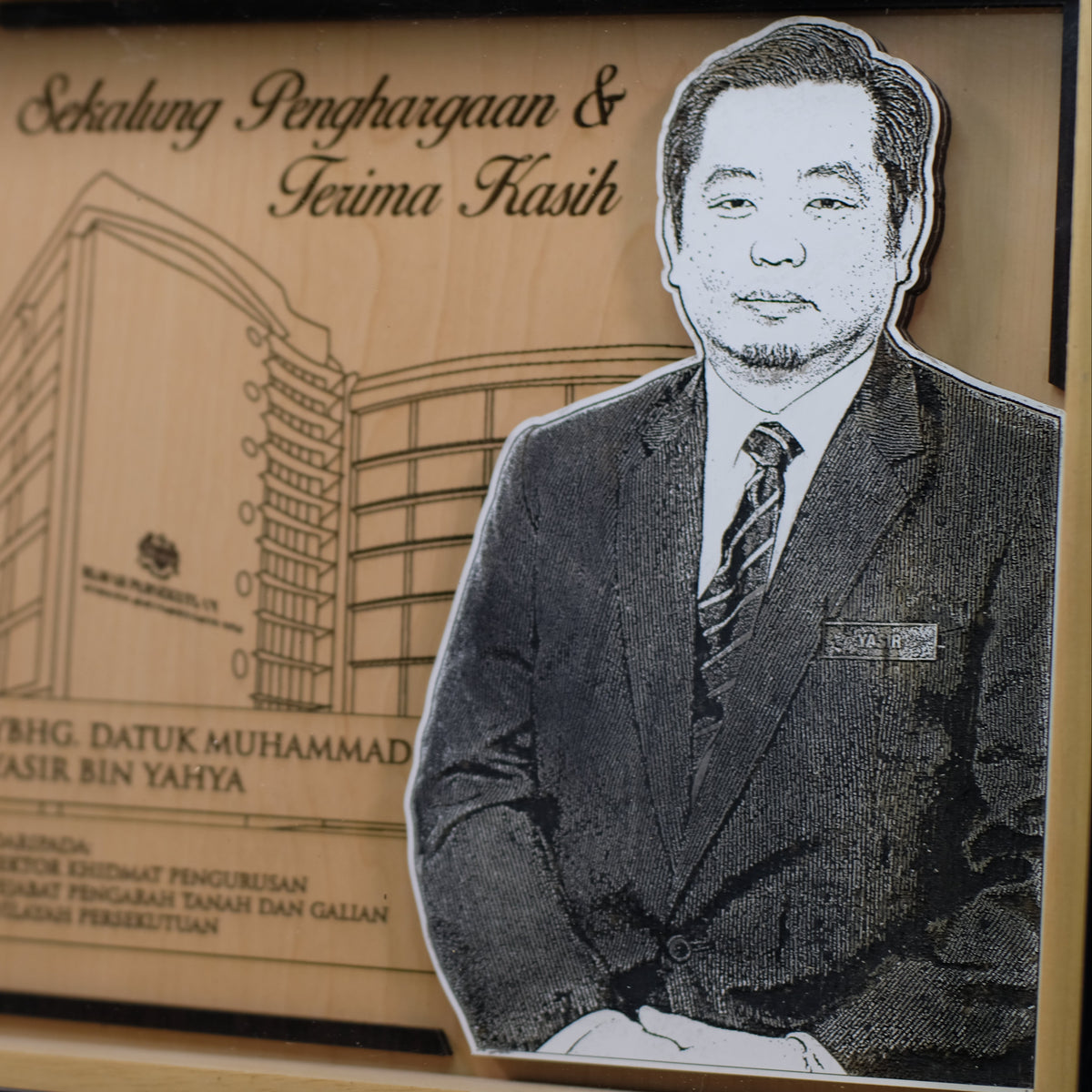 Plaque with a portrait of a man in a suit and text on a wooden background
