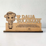 A custom wooden table stand signage with an engraved portrait and text, displayed on a desk.