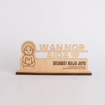 Wooden plaque with engraved text and a cartoon character on a white background