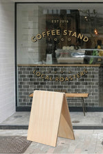 Coffee stand with 'Local Roasters' sign on a tiled wall