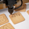 Laser engraving machine on cookies with '2019' and letter 'B' engraved.