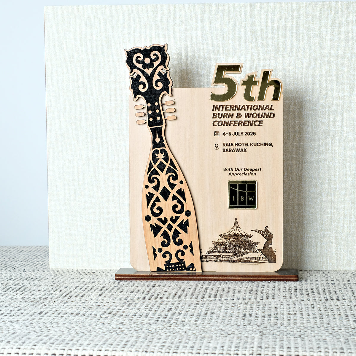 Wooden award with decorative design on a stand against a light background