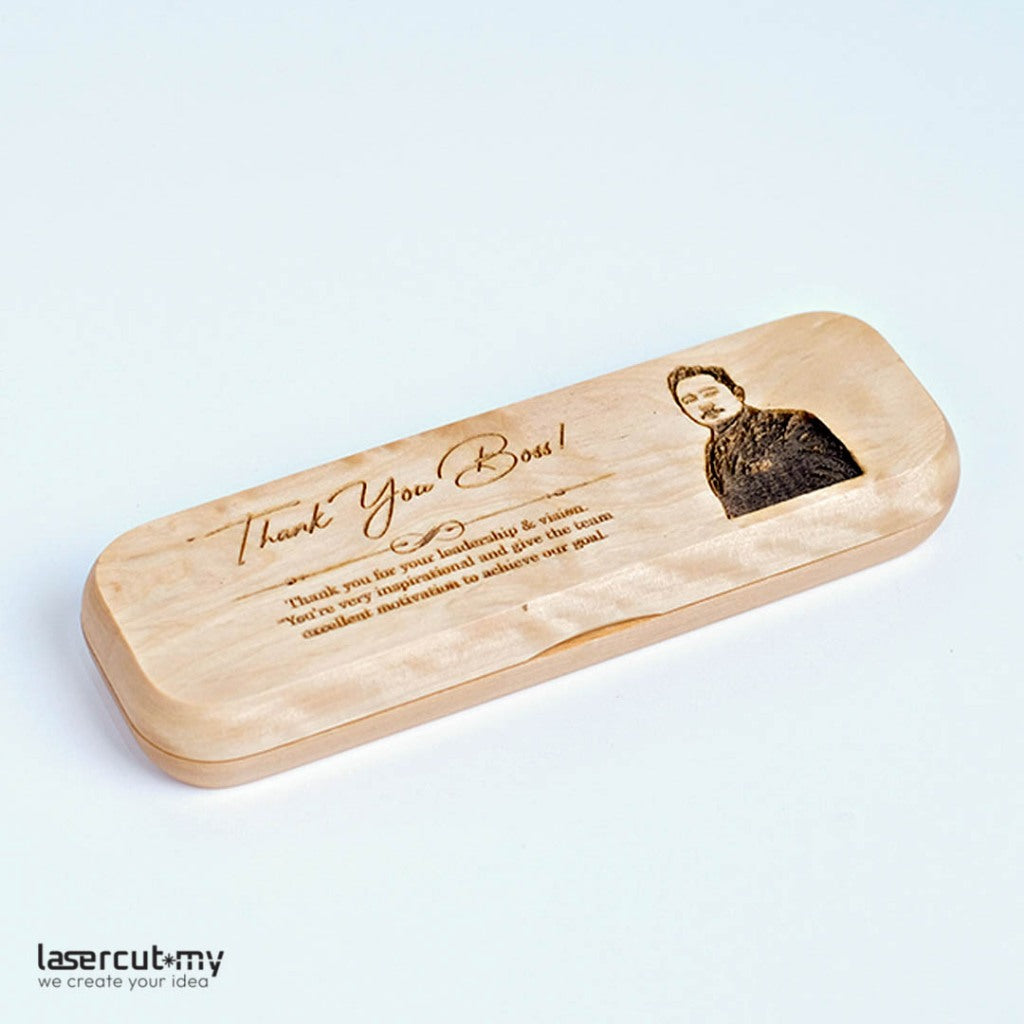 A personalized wooden pen with gold accents, engraved with a name, placed in an open wooden box with a lid, on a white background.