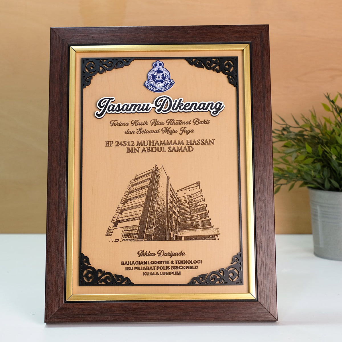 Framed certificate with a building illustration on a wooden surface