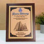 Framed certificate with a building illustration on a wooden surface
