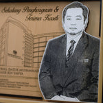 Plaque with a portrait of a man in a suit and text on a wooden background