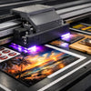 Digital printing process with a large printer and printed materials on a table.